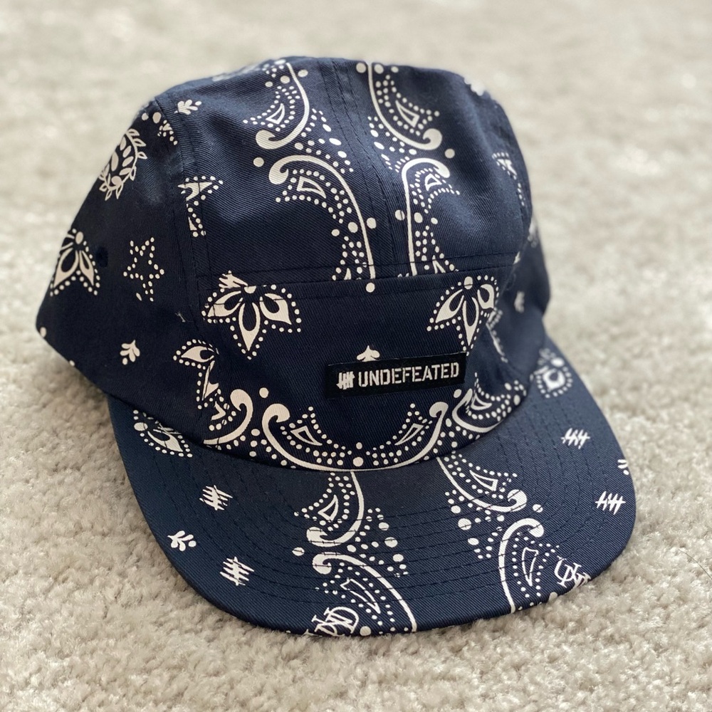 UNDEFEATED SWEAT PROOF CAP WITH ADJUSTABLE STRAP.